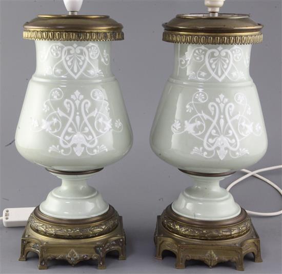 A pair of Paris porcelain pate-sur-pate celadon ground and ormolu mounted lamp bases